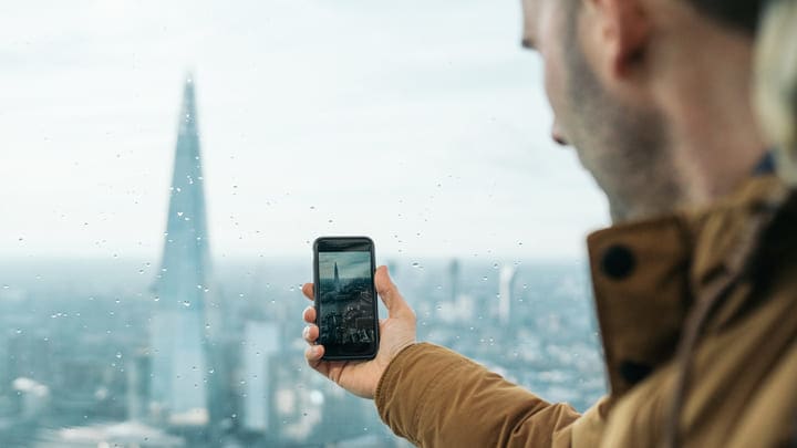 Man taking a photo of The Shard in London